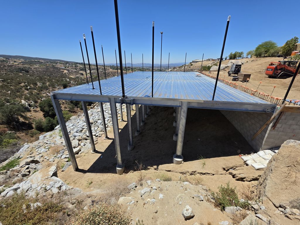 Wide view of the hillside steel deck showing the steel column and beam layout and the hillside setting